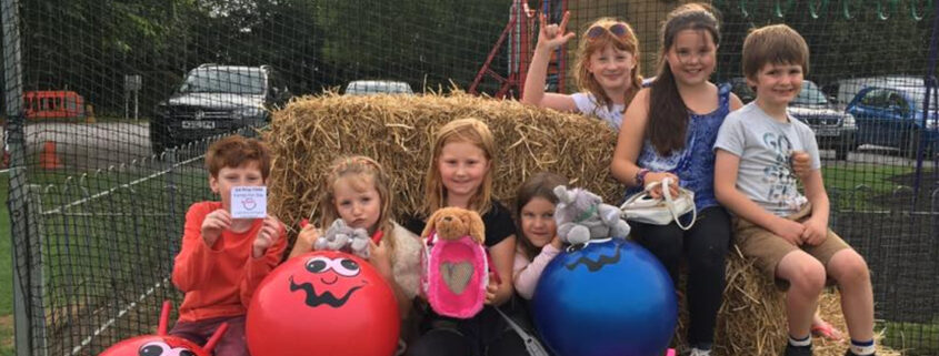 Young children sitting on haystacks